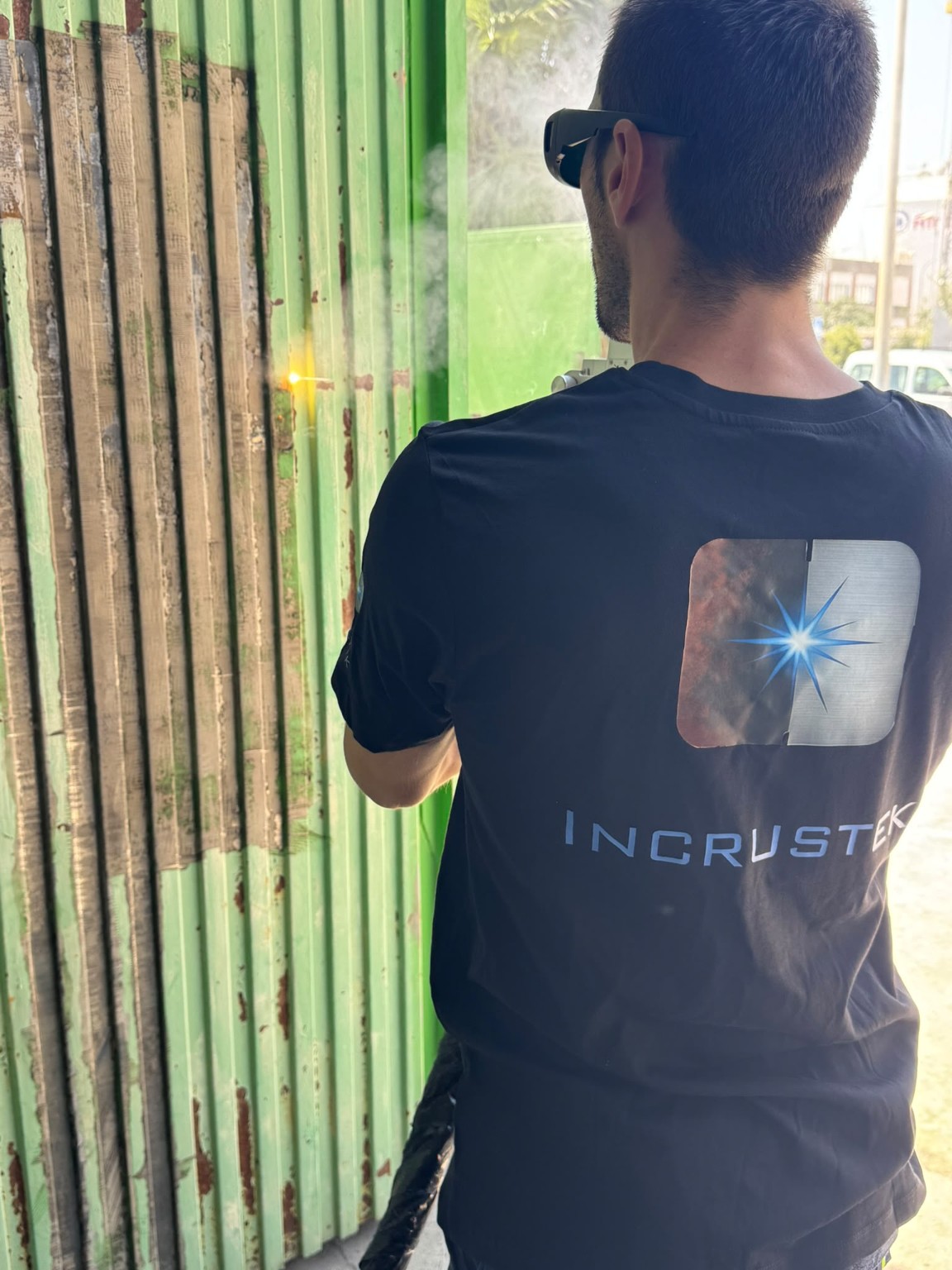 Técnico de INCRUSTEK preparando con láser una puerta metálica oxidada